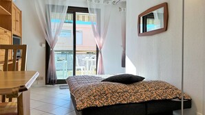 A bedroom with a bed, a desk, and a chair.