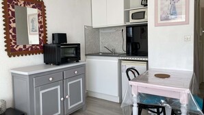 Una cocina pequeña equipada con microondas, tostadora y cafetera.