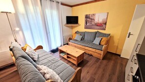 Un salon confortable avec un canapé, une table basse en bois et un téléviseur.