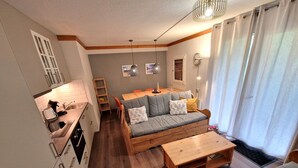 Un salon moderne avec un canapé, une table basse et un coin repas.