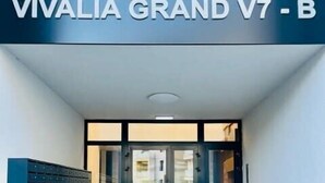 The entrance to Vivalia Grand V7 - B with a modern design, featuring a glass door and a blue mailbox on the wall. - Joy City Stay Vivalia 7B-26 (Timișoara)