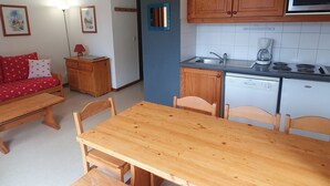 Una cocina compacta con armarios de madera, un microondas y un lavavajillas.