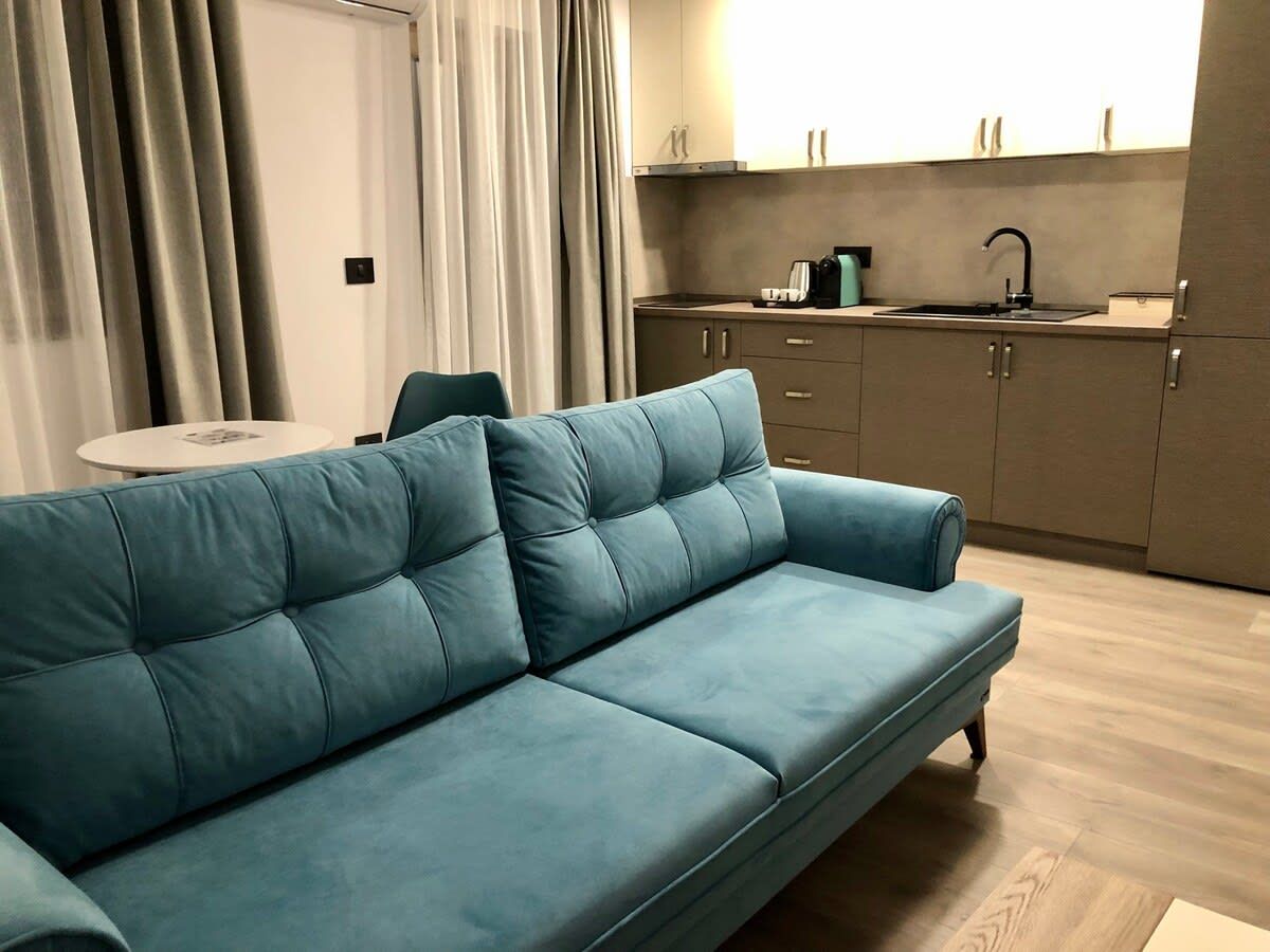 Un espace de vie moderne comprenant un canapé, une table à manger et une cuisine en arrière-plan.