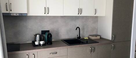 A modern kitchen with a built-in sink, a coffee maker, and a toaster.