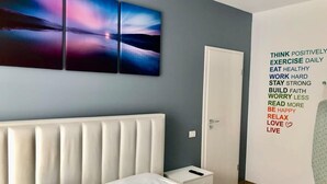 Una camera da letto con un letto, un comodino e una parete con citazioni motivazionali.