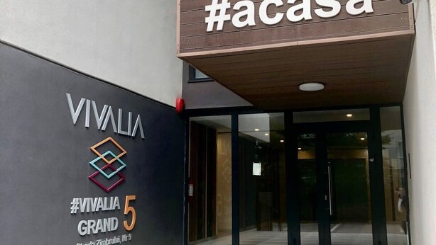 L'ingresso del Vivalia Grand, caratterizzato da un design moderno con un'insegna #acasa ben visibile sopra l'entrata.