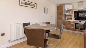 A modern kitchen with a built-in microwave, oven, and wooden cabinets. - Luxury Two Bedroom Apartment Apt 4 (York)