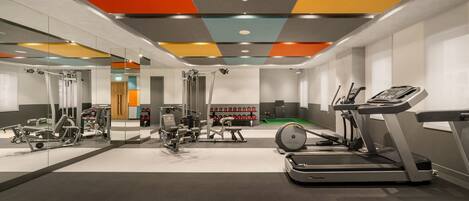 A modern gym with various exercise equipment, including treadmills and weight machines.