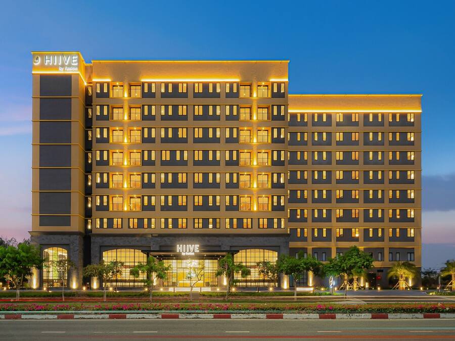 Een hotel met meerdere verdiepingen en een moderne gevel, met een opvallend bord bovenaan.