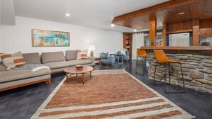 Una sala moderna con sofá, una mesa de centro y una pared decorativa de piedra.