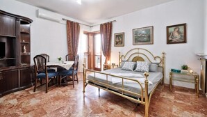 A bedroom with a bed, a desk, and chairs. - Apt Venice City (Mestre)