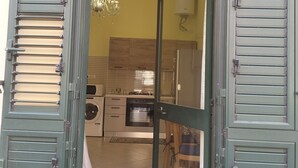 A kitchen with modern appliances, a chandelier, and a view into the living area. - Apartment a few minutes from the Sea (Letojanni)