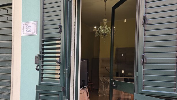 A hotel entrance with green shutters, a chandelier inside, and a sign reading "Casa Nicole". - Apartment a few minutes from the Sea (Letojanni)