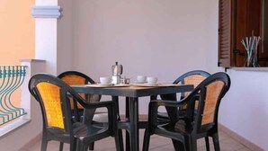 Ein Esstisch mit vier Stühlen, einer Kaffeekanne sowie einigen Tassen und Untertassen.