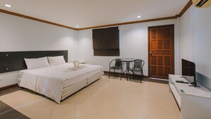 A bedroom with a bed, a desk, a chair, and a door. - sunstar palace patong (Patong)