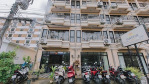 A multi-story building with balconies, a sign for 'SUNSTAR Palace', and several parked scooters. - sunstar palace patong (Patong)