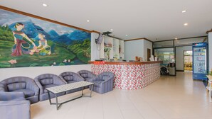 A lobby with a mural, seating area, reception desk, and a vending machine. - sunstar palace patong (Patong)