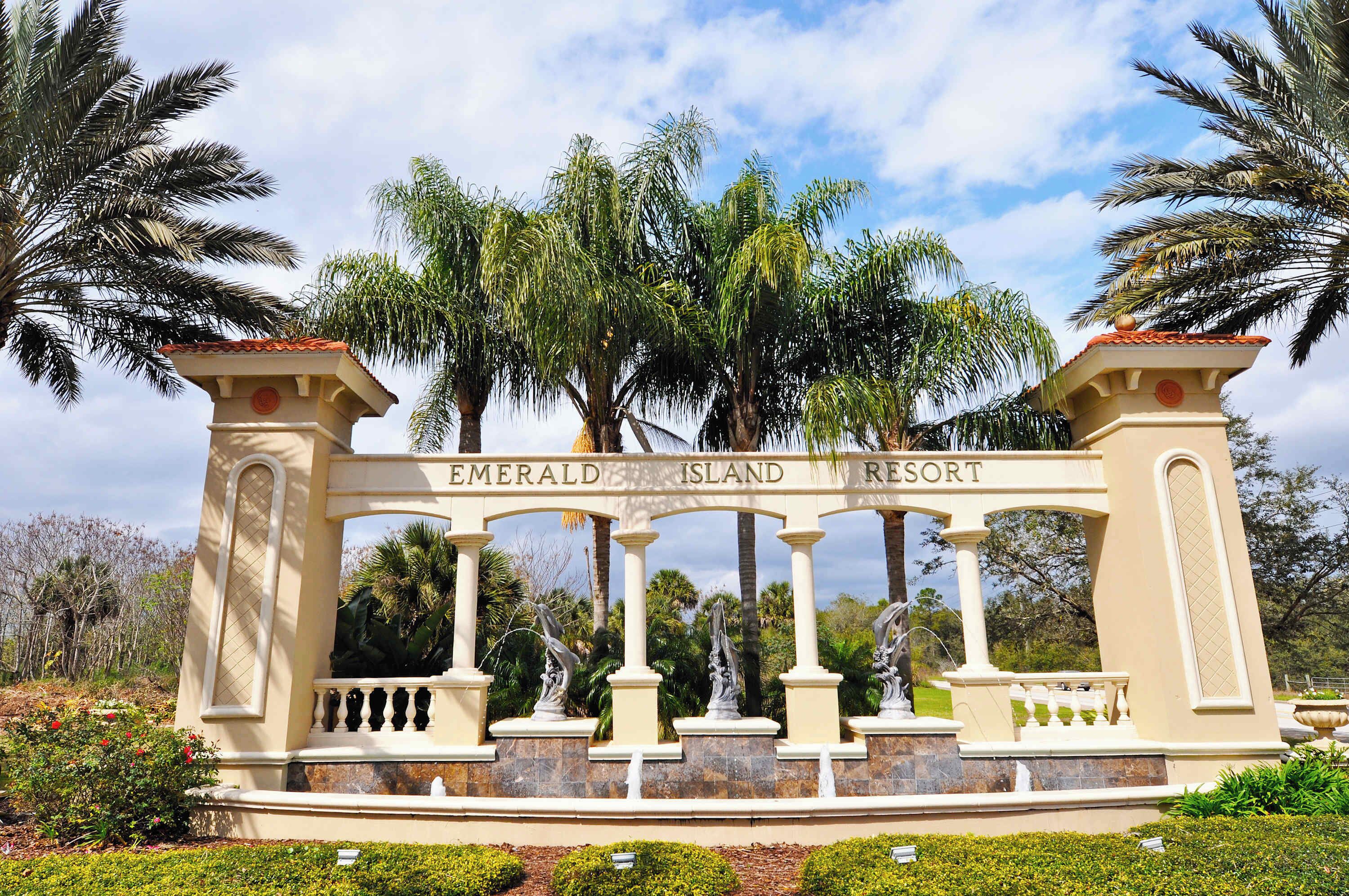 Señal de Emerald Island Resort con arquitectura clásica, que presenta columnas y un arco central.