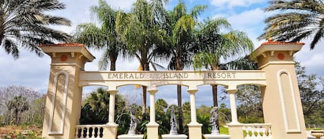 Señal de Emerald Island Resort con arquitectura clásica, que presenta columnas y un arco central.