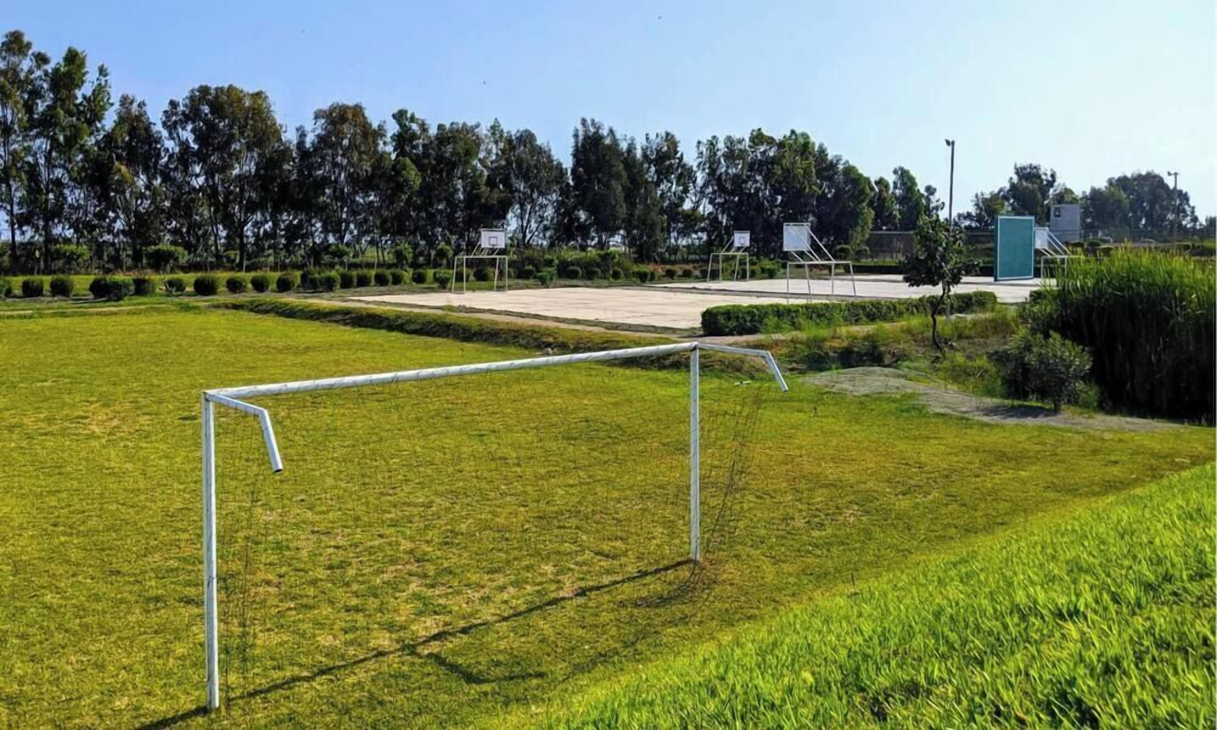 Een voetbalveld met doelpalen en een groen gazon.