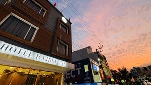 A hotel named "RAJDEV INN" with a signboard, a visible entrance, and a clear view of the sky. - Hotel Rajdev INN  (Ujjain)