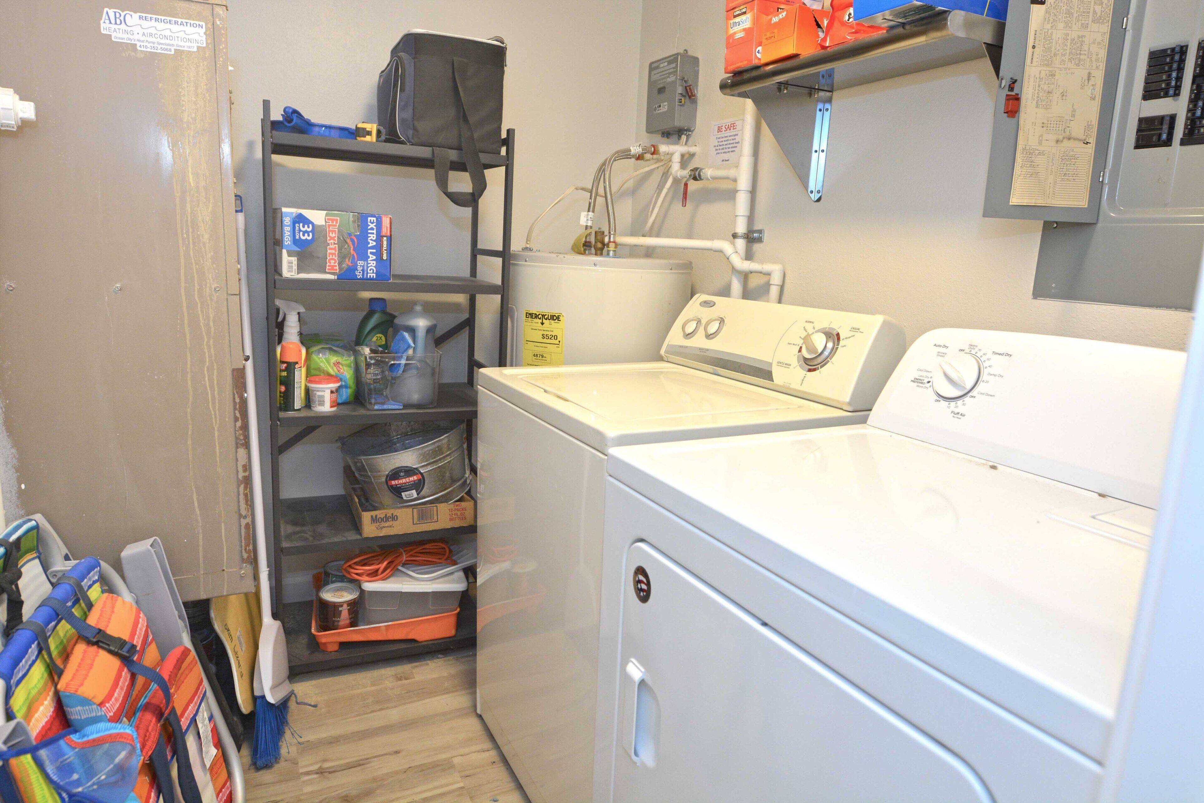 A laundry area with a washing machine, shelves with cleaning supplies, and a utility room with electrical panels.