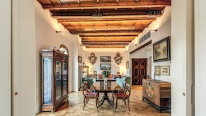 A dining area with a wooden ceiling, a round table, and chairs. - Trastevere Outstanding  4 BR Terraced Apartment (Roma)
