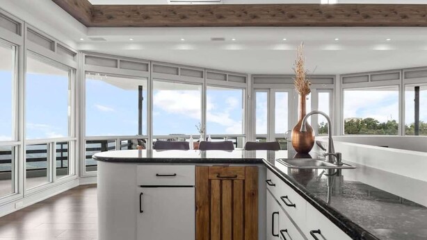Una cocina moderna con ventanas amplias, una isla central y vistas al exterior.