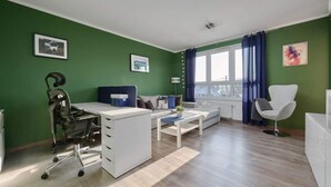 Una sala de estar moderna con escritorio, sofá y sillón.