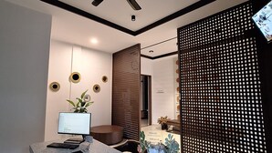 Un espace de bureau moderne, doté d’une grande table, d’un ordinateur et d’un ventilateur de plafond.