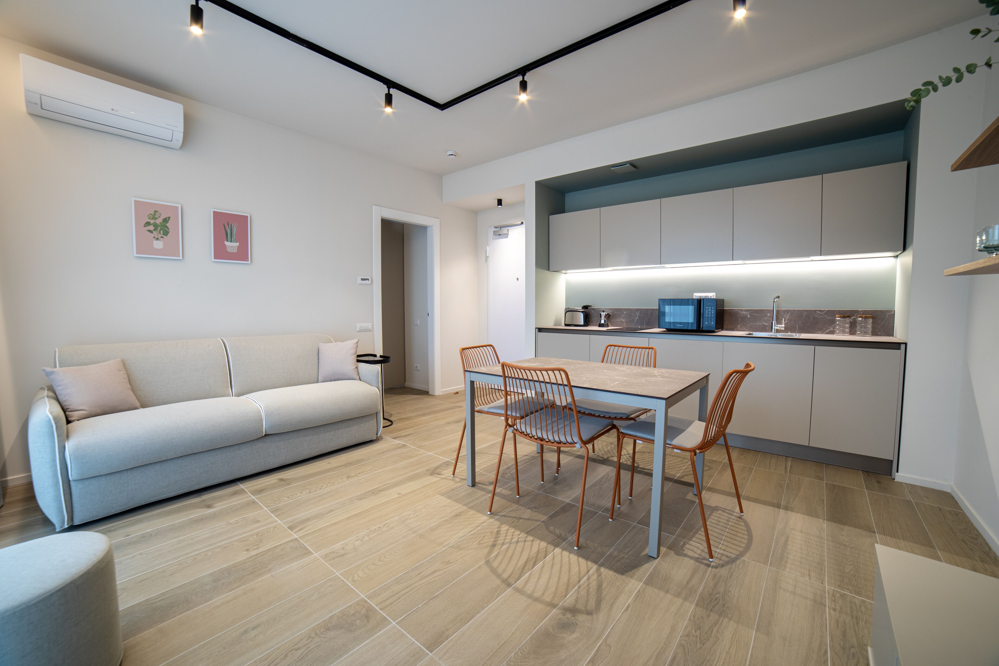 Una cocina moderna con comedor, que incluye un sofá, una mesa y sillas.