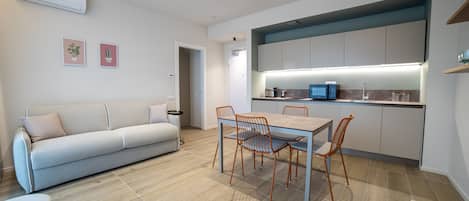 Une cuisine moderne avec un coin repas, comprenant un canapé, une table à manger et des chaises.
