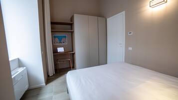 Una camera da letto con un letto, una scrivania e un armadio.