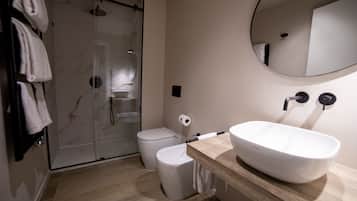 Un bagno moderno con cabina doccia in vetro, un water e un lavandino capiente con specchio.