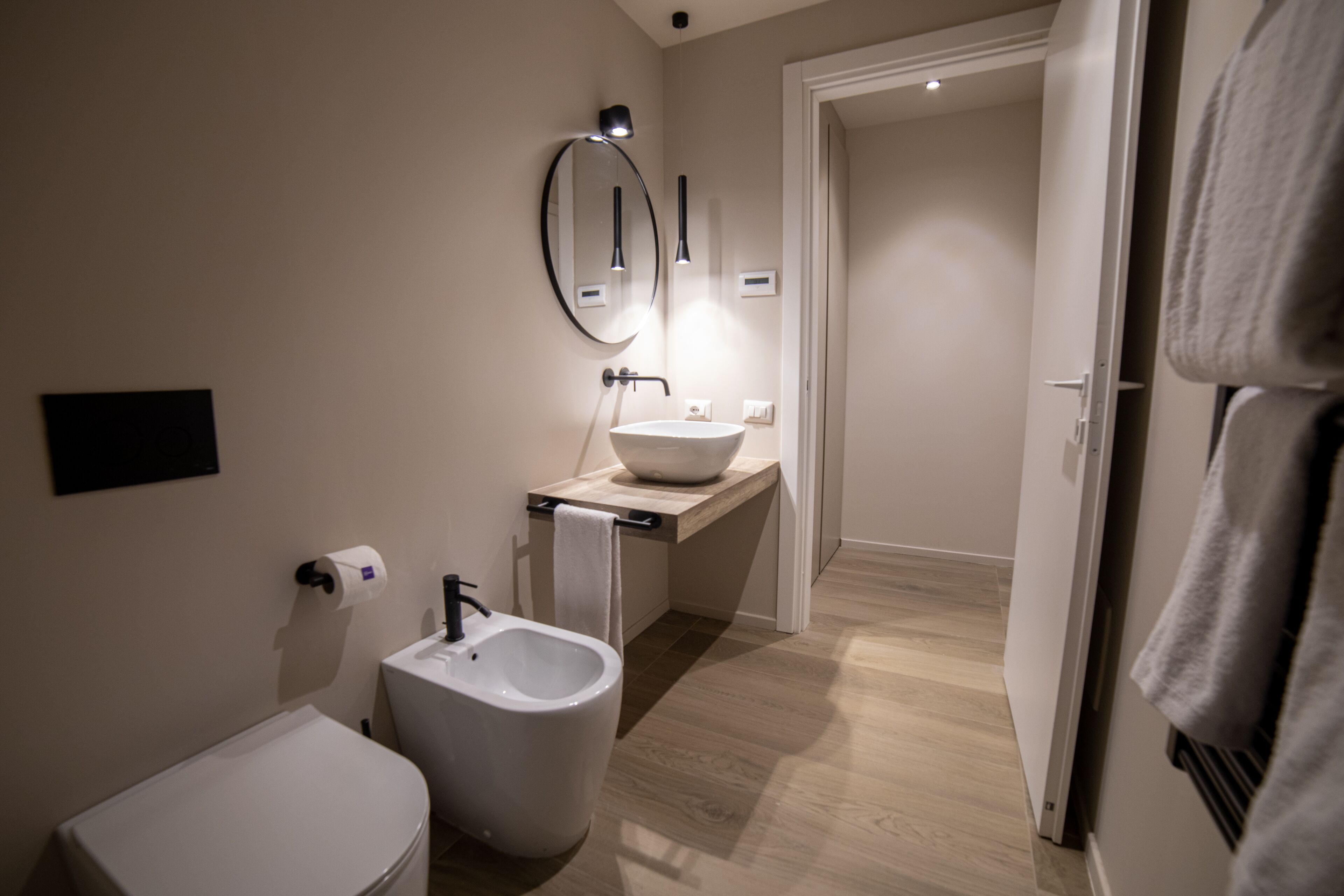 Un bany modern amb bidet, vàter, rentapel i mirall.