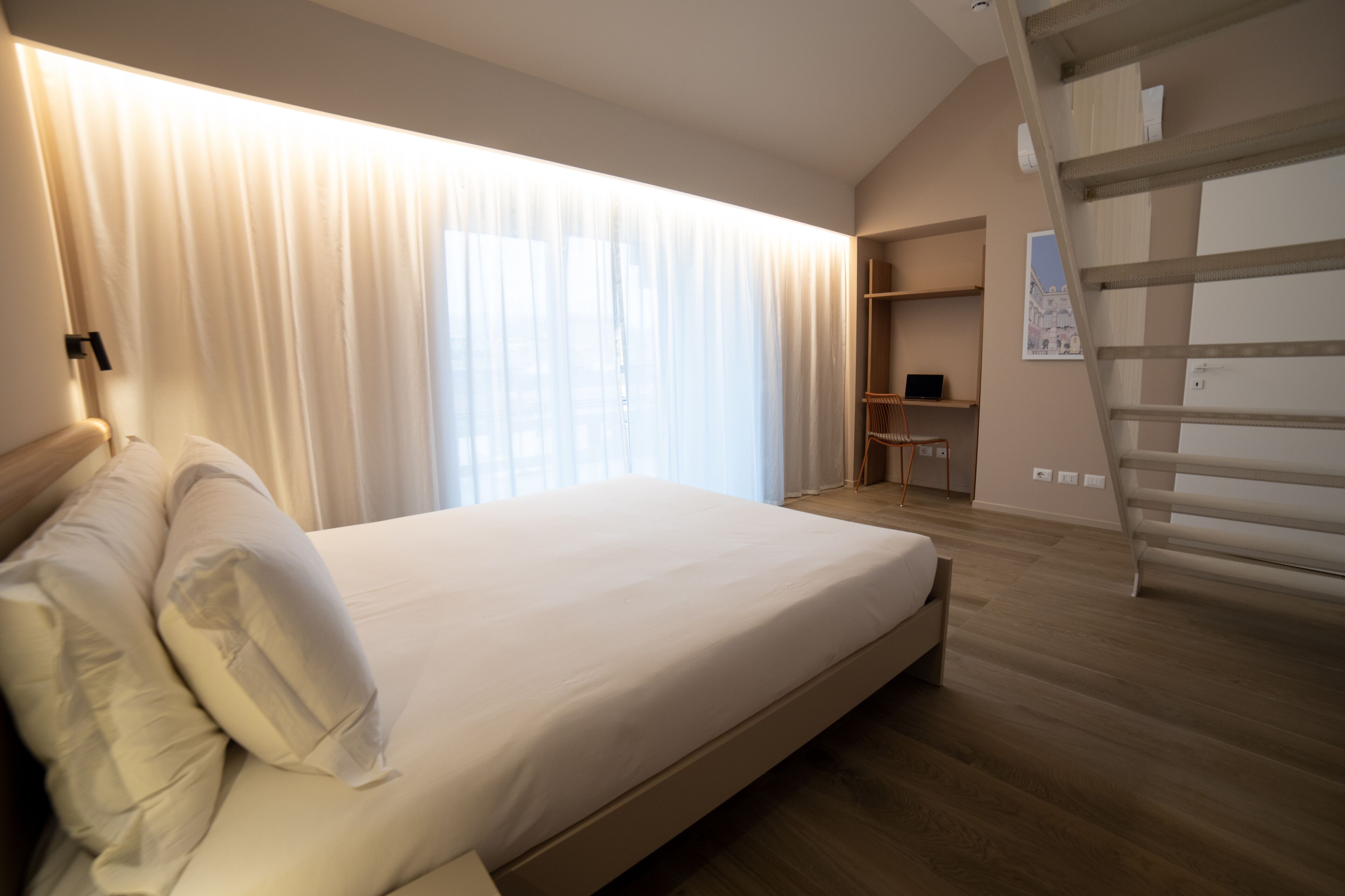 A bedroom with a bed, a desk, and a chair.