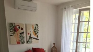 A bedroom with a bed, two wall art pieces, a nightstand, and a window with curtains. - Maison Périgoudine (Saint-Philippe-d'Aiguille)