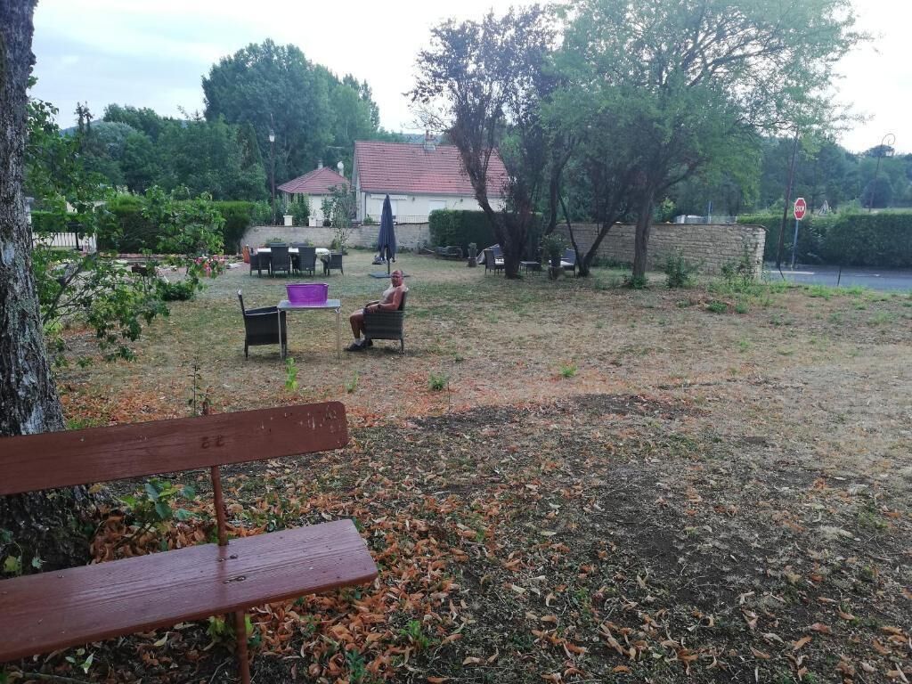 A park with a bench, a table, and chairs.