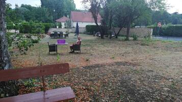 A park with a bench, a table, and chairs.
