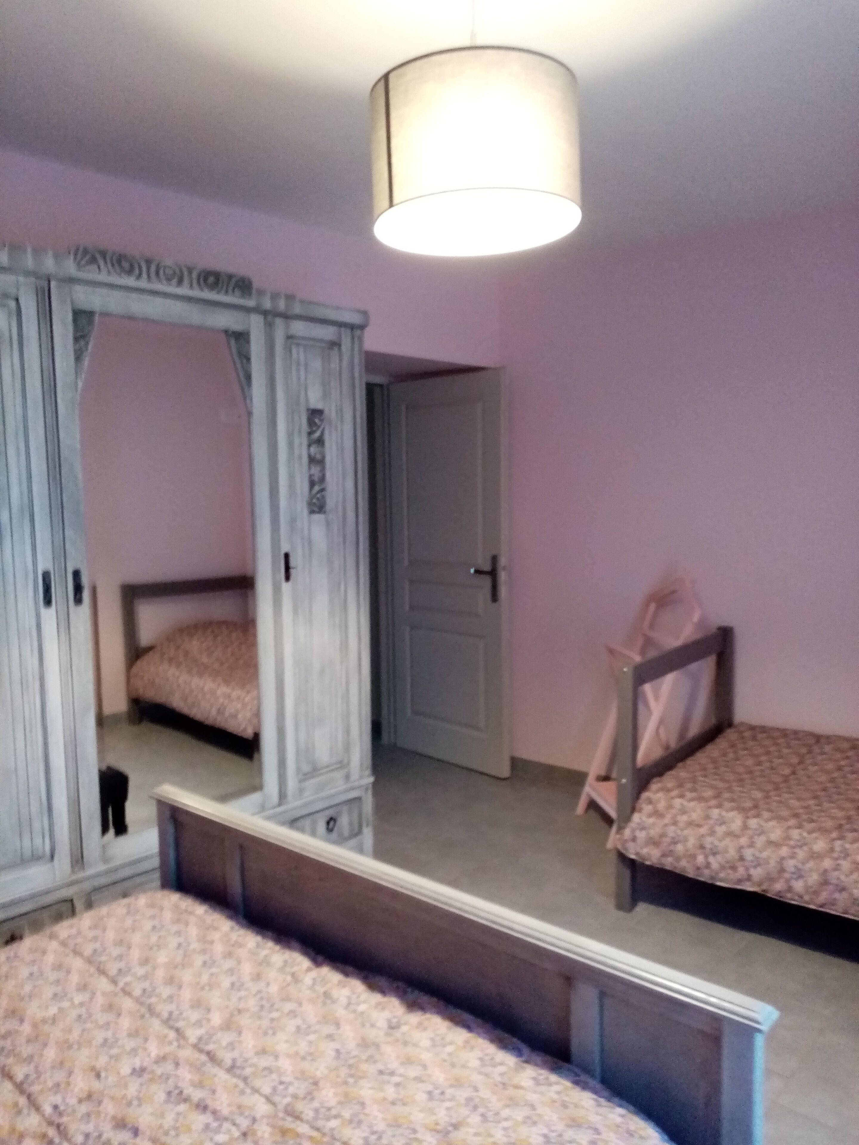 Ein Schlafzimmer mit zwei Betten, einem Kleiderschrank und einem Spiegel.
