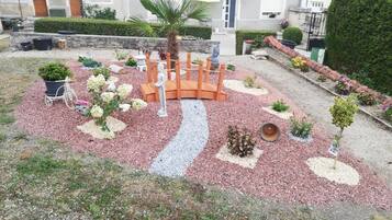 A garden with a circular wooden bench, a palm tree, and various plants.
