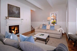 A living room with a fireplace, a sofa set, a coffee table, and a window with a view. - The Victorian Gem, Luxury Home, Heart of CB (Crested Butte)