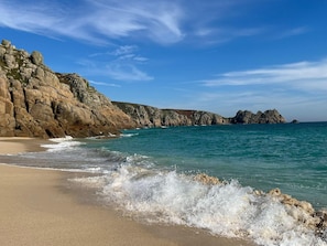 A coastal landscape with rocky cliffs and a sandy beach. - Panoramic sea views, overlooking the beach – on the South West Coast Path (Penzance)