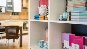 A bookshelf with books, a teapot, and a small toy car. - One bedroom apartment with free parking, WIFI (Zagreb)