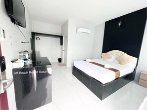 Ein modernes Hotelzimmer mit Bett, Schreibtisch und Fernseher.