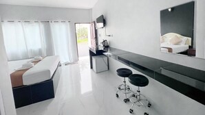 Habitació d'hotel moderna amb un llit, una taula de treball, una cadira, un mirall i vistes a l'exterior.