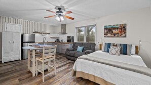 A compact living space with a kitchenette, a dining area, a sofa, and a bed. - Renovated Rustic Charm! (New Bern)