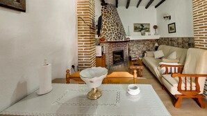 Un salon chaleureux avec une cheminée, un canapé et une table agrémentée d’objets décoratifs.