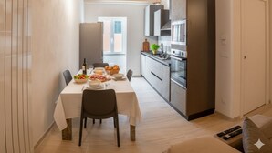 Ett modernt kök med matplats, träbjälkar i taket och utsikt över omgivningen.
