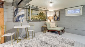 A cozy room with a white round table, two chairs, a green armchair, and a patterned rug. - Quaint Studio w/ Sauna: 5 Mi to Space Needle (Seattle)